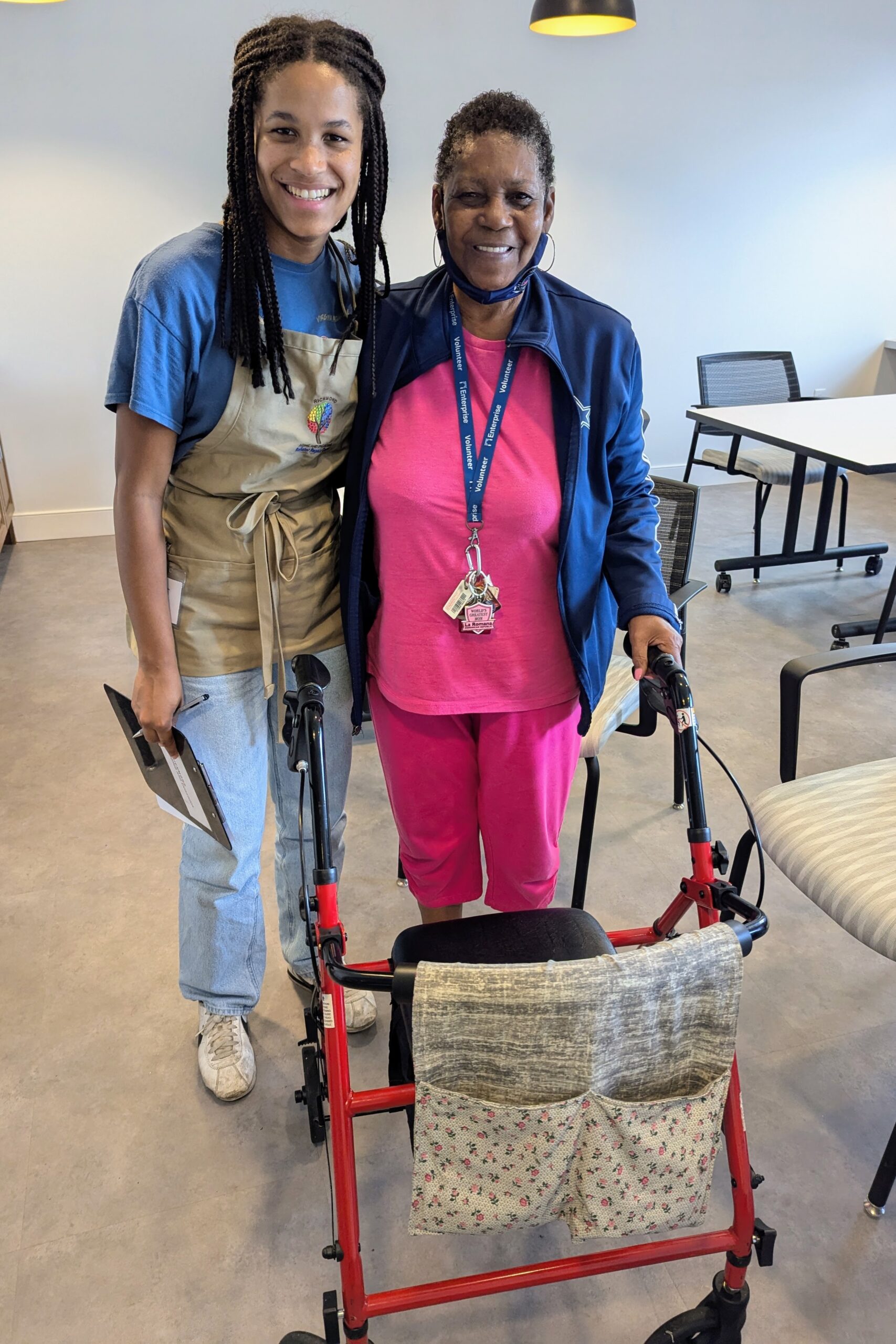 Older adult participant with volunteer showing repaired rollator.