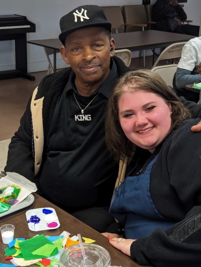 Volunteer and older adult participant smiling.