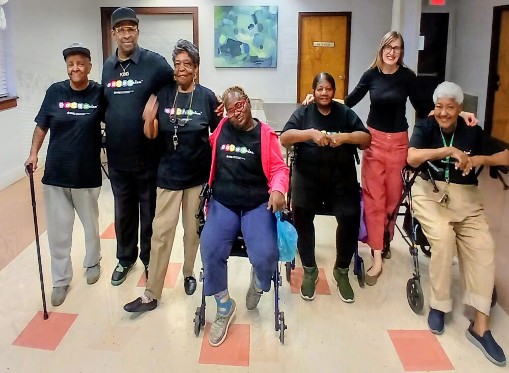 Older adult participants pose with Director Jodi Winship wearing Bingocize shirts.