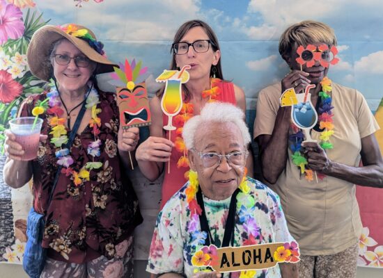 Director Jodi Winship and three participants pose in Hawaiian attire.
