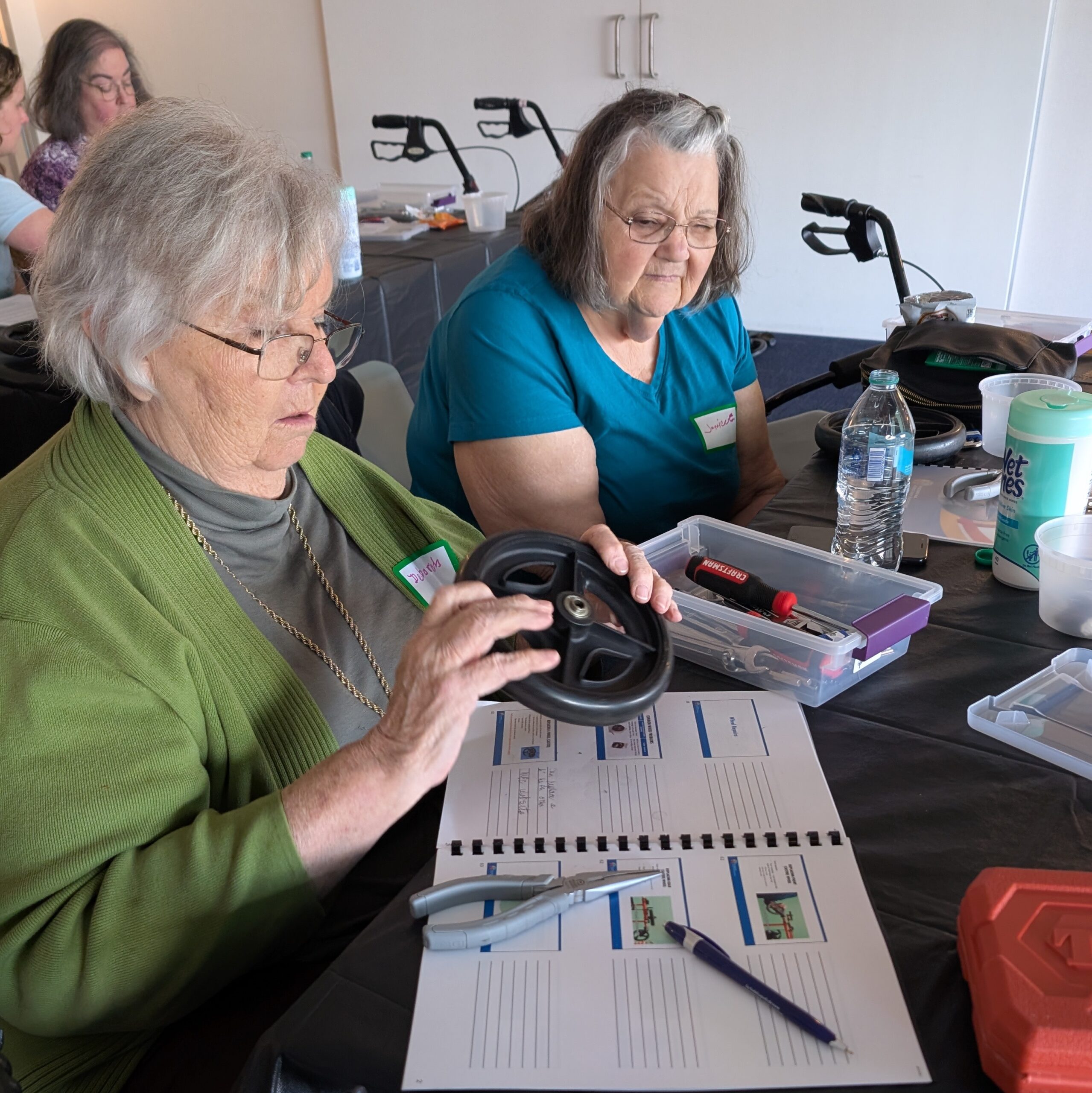 Two older adult participants learning how to repair a rollator.