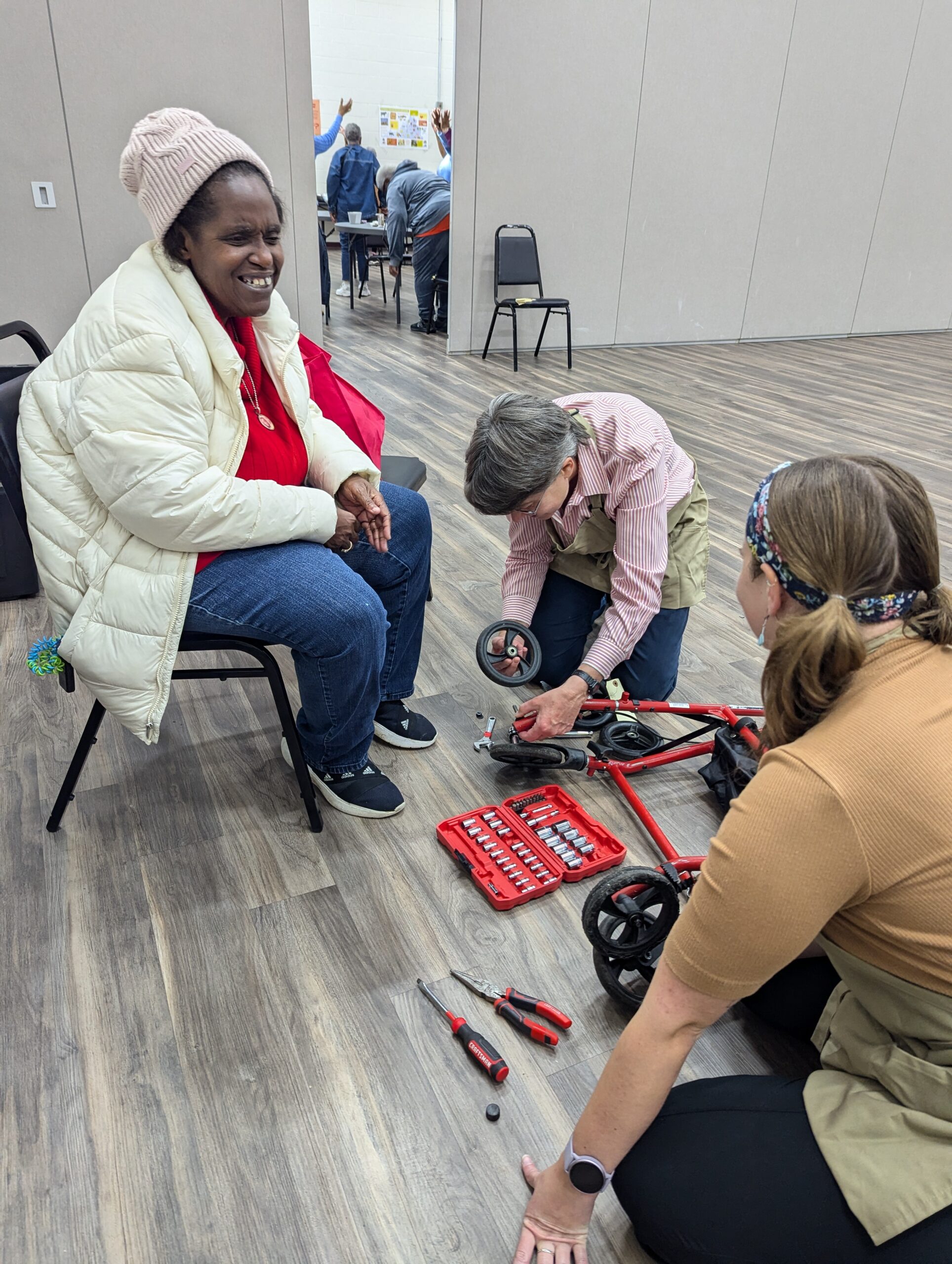 Rollator repair corps fixing broken rollator for an older adult participant.