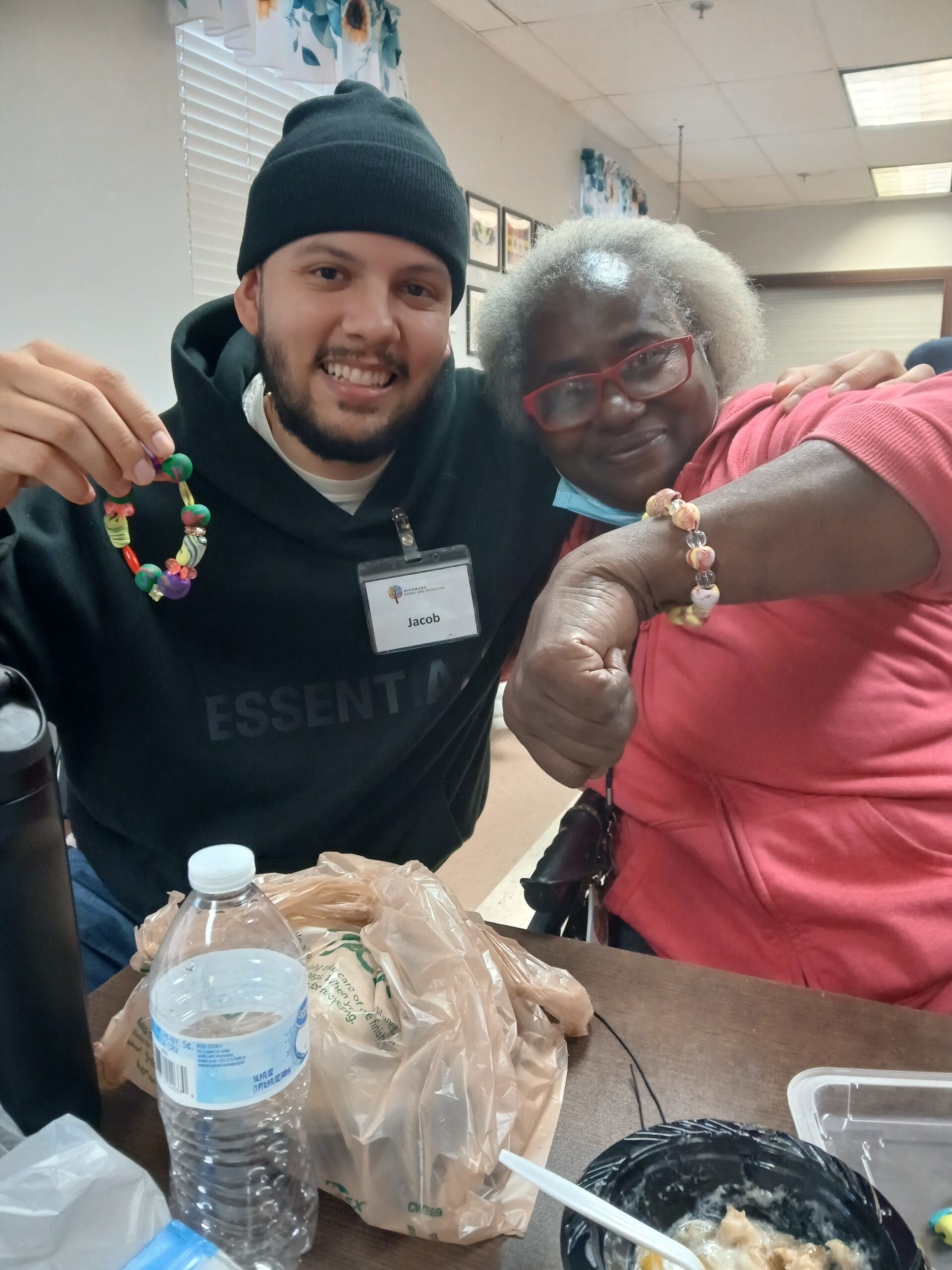Volunteer and participant showing off their handmade charm bracelets.